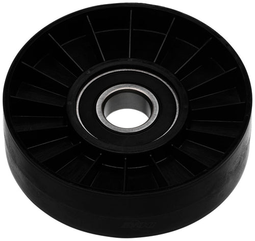 Black automotive idler pulley with visible central metal bearing and radial ribbed plastic face on white background