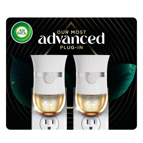 Two white Air Wick advanced plug-in warmers shown inserted in outlets with golden scented oil reservoirs on dark decorative background.