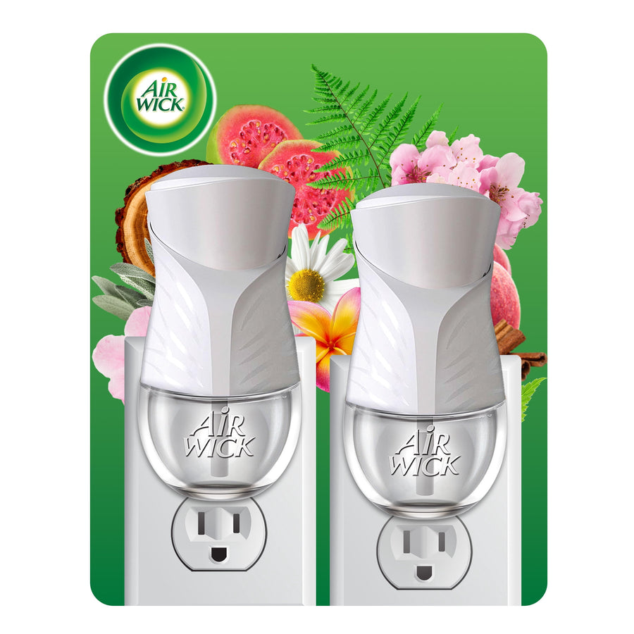 Two white Air Wick plug-in oil warmers shown inserted in outlets against floral backdrop