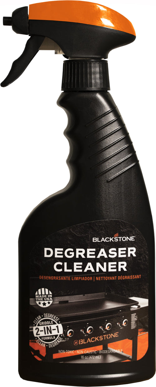 Close-up of a Blackstone Degreaser Cleaner black spray bottle with orange top and product label