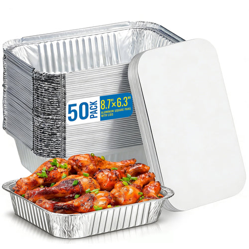 Stacked disposable aluminum baking pans with a lid and a filled pan of glazed chicken drumsticks in front.