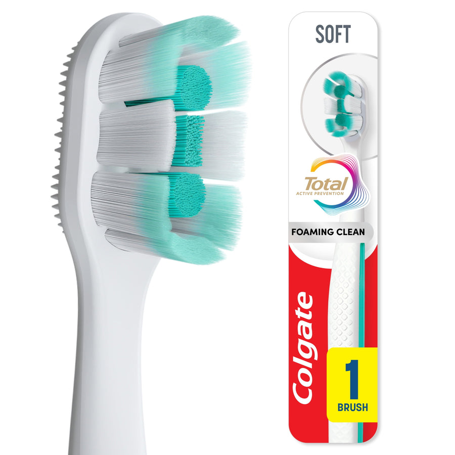Close-up of Colgate Total Active Prevention toothbrush head showing soft mint-green and white bristles and side rubber polishing pad.