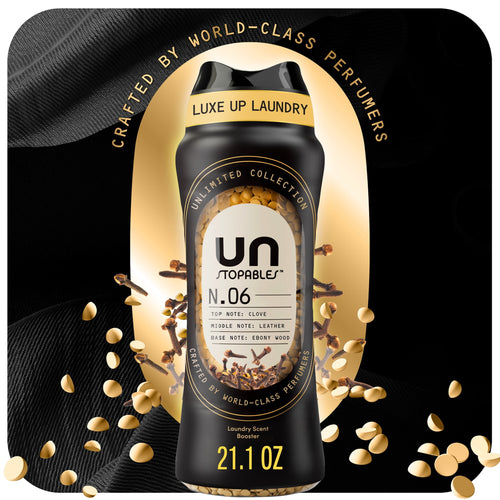 Black Downy Unstopables N.06 bottle with visible scent beads and gold accents on a dark luxe background.