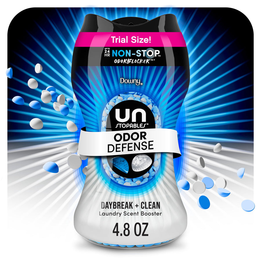 Close-up of a Downy Unstopables Odor Defense Daybreak + Clean bottle with blue scent beads and radiant blue background