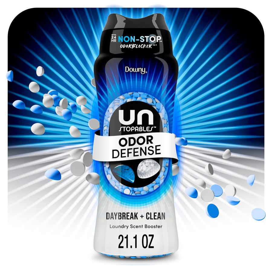 Close-up product shot of a Downy Unstopables Odor Defense Daybreak + Clean scent beads bottle with blue burst graphic
