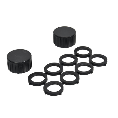 Loose black plastic flat washers and two textured black plastic caps arranged on white background.
