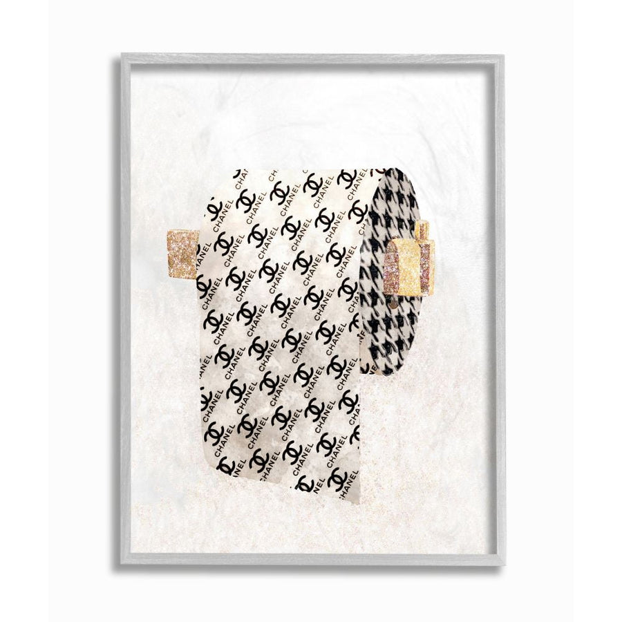 Framed stylized toilet-paper roll art print with repeating Chanel-like logo pattern and glitter accents on a light textured background.