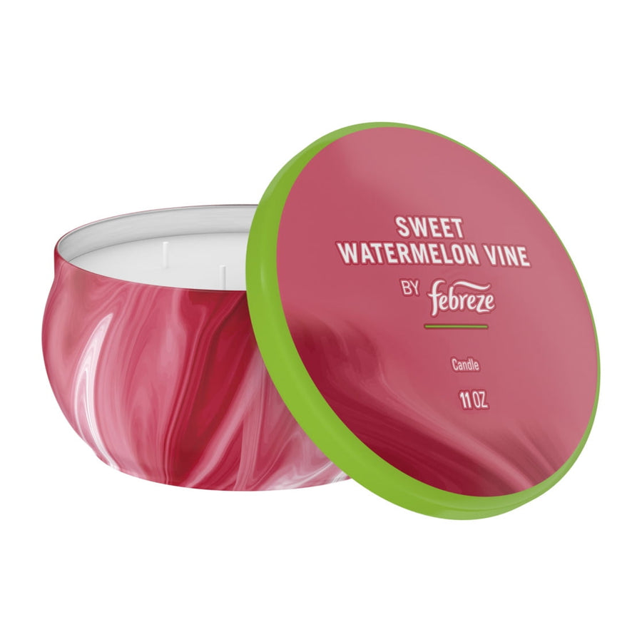 Febreze Sweet Watermelon Vine scented tin candle with lid propped to the side, white wax and four wicks visible