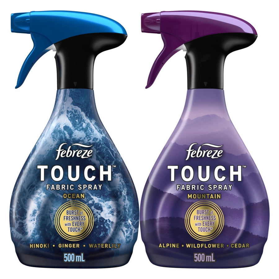 Two Febreze Touch fabric spray bottles side-by-side showing Ocean (blue) and Mountain (purple) scent labels and trigger tops.