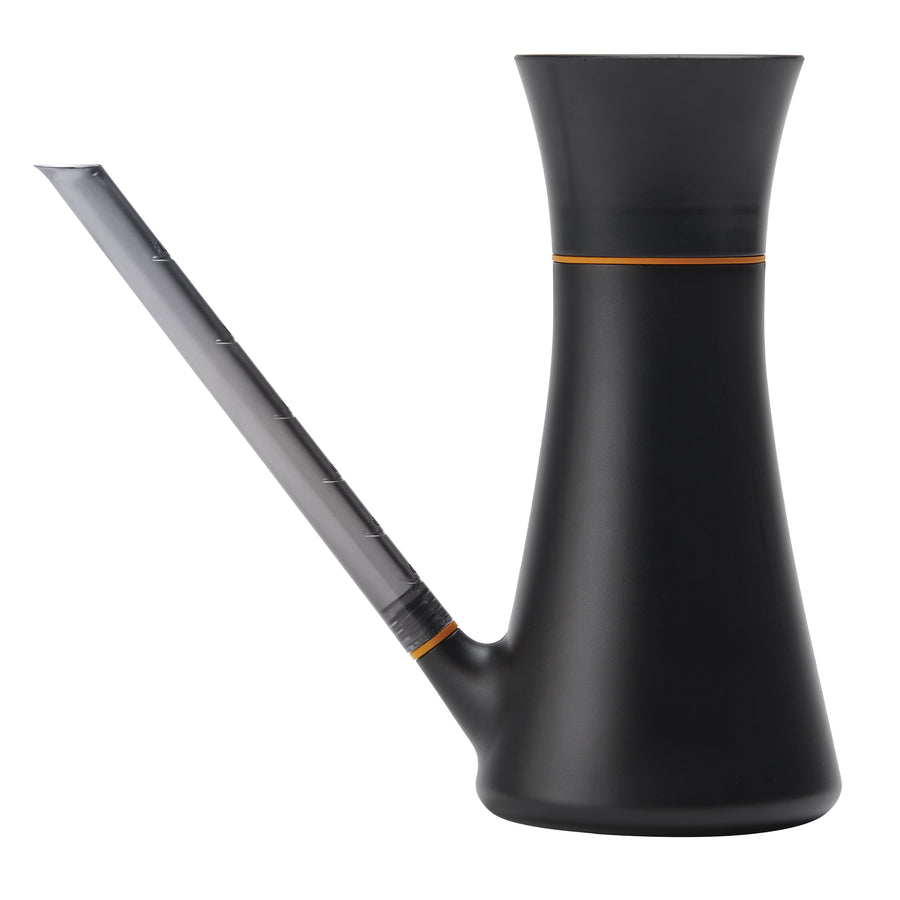 Matte black Fiskars indoor watering can with translucent angled spout and orange trim, side view