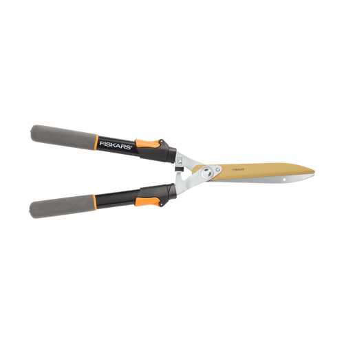 Pair of Fiskars hedge shears with long black handles and gold-titanium coated blades on white background