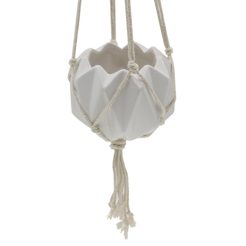 Matte white geometric ceramic hanging planter suspended in a knotted macramé hanger, close-up detail.