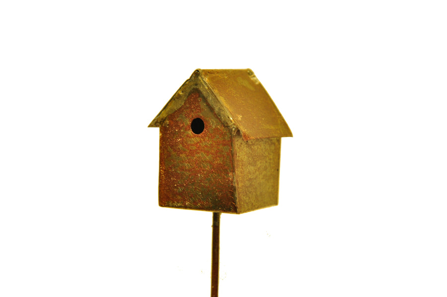 Small antique-brass miniature metal birdhouse on a thin stake against a white background