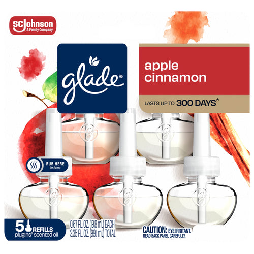Front packaging close-up of Glade Apple Cinnamon plug-ins showing logo, apples, cinnamon stick, and refill bottles