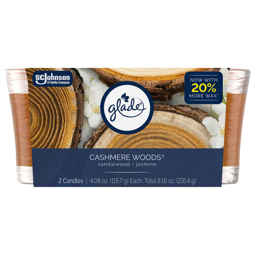 Glade Cashmere Woods twin glass candles in retail packaging showing wood-grain label, Glade logo and 'Now with 20% more wax' badge.