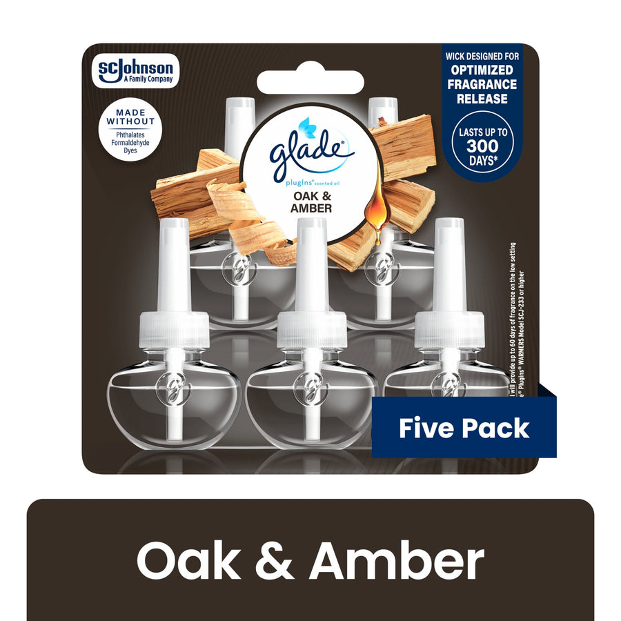 Retail blister pack of Glade plug-in scented oil refills in Oak & Amber showing five clear refill bottles and wood imagery