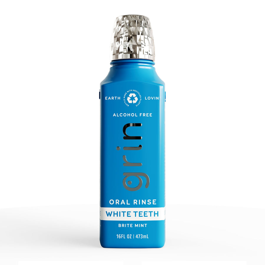 Tall blue Grin oral rinse bottle with silver textured cap labeled 'White Teeth' and 'Oral Rinse' on white background.