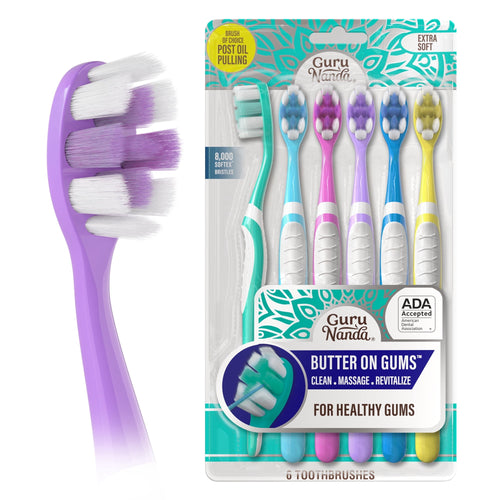 Packaged GuruNanda Butter On Gums toothbrushes in six pastel handles with ADA accepted badge and close-up purple brush head