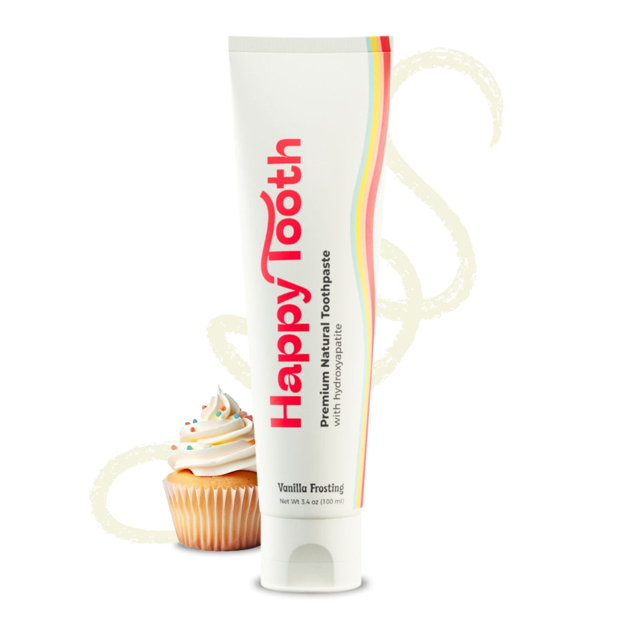 Tube of Happy Tooth vanilla frosting toothpaste standing beside a cupcake with a swirled cream background.