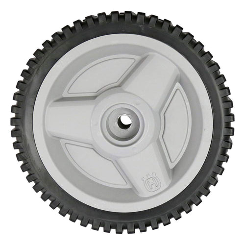 Close-up of a Husqvarna branded gray plastic wheel with black treaded rubber tire and central hub