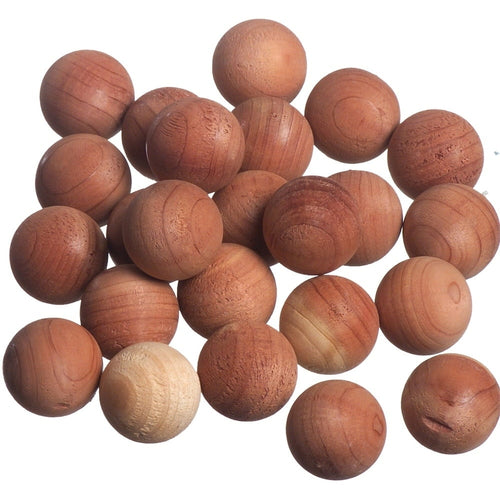 Cluster of small round natural cedar wood balls on a white background showing wood grain texture