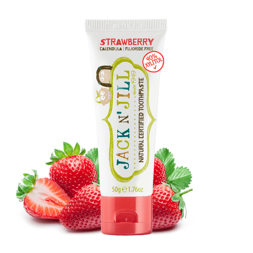 Jack N' Jill strawberry kids toothpaste tube with strawberries arranged behind it on white
