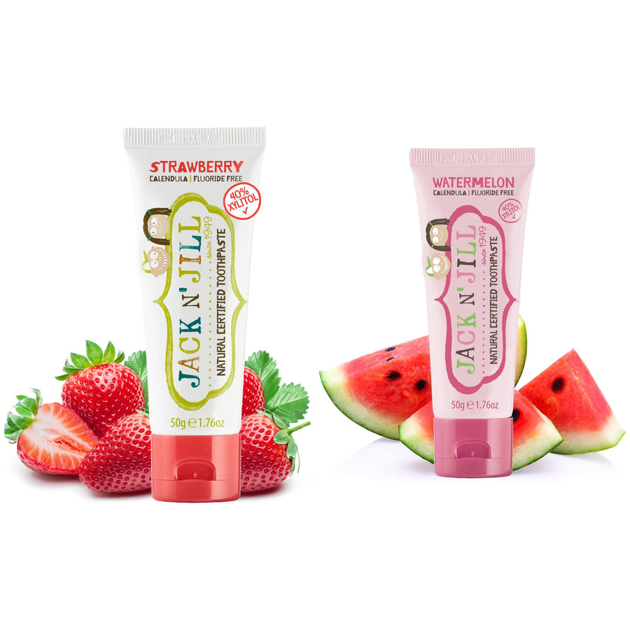 Two Jack N’ Jill toothpaste tubes, strawberry and watermelon, with matching fruit slices behind them