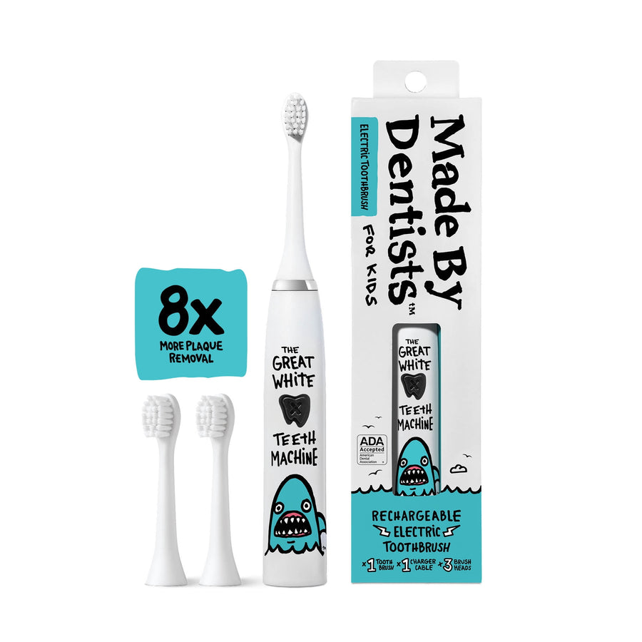 Made By Dentists white kids electric toothbrush with shark graphic, two replacement heads and retail box on white background.