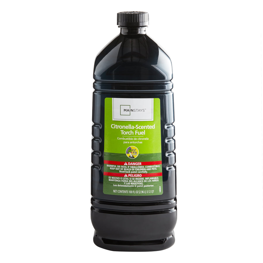 Tall black plastic jug of Mainstays citronella-scented torch fuel with green warning label on white background.