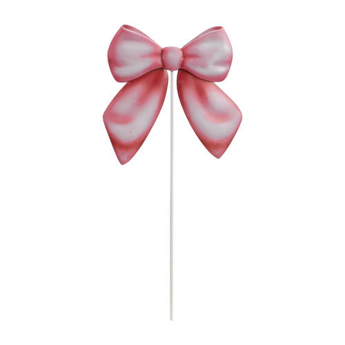 Pink painted metal bow mounted on a thin white garden stake against a white background