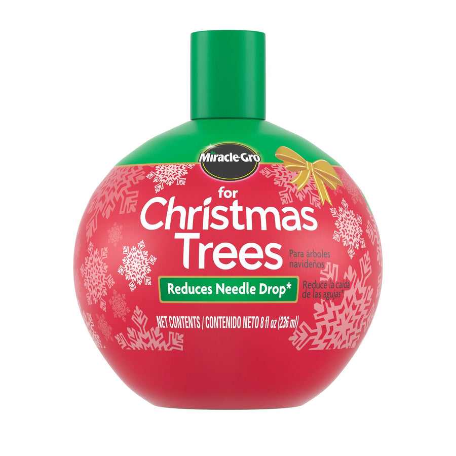 Round red Miracle-Gro for Christmas Trees bottle with green cap and snowflake design on a white background.