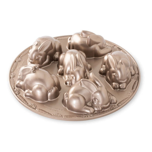 Round metallic baking pan with six detailed bunny-shaped cavities arranged in a circle