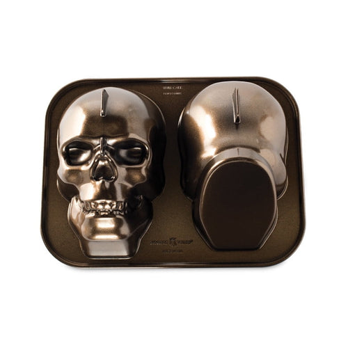 Nordic Ware cast-aluminum skull cake pan showing two detailed skull-shaped cavities on a baking tray.