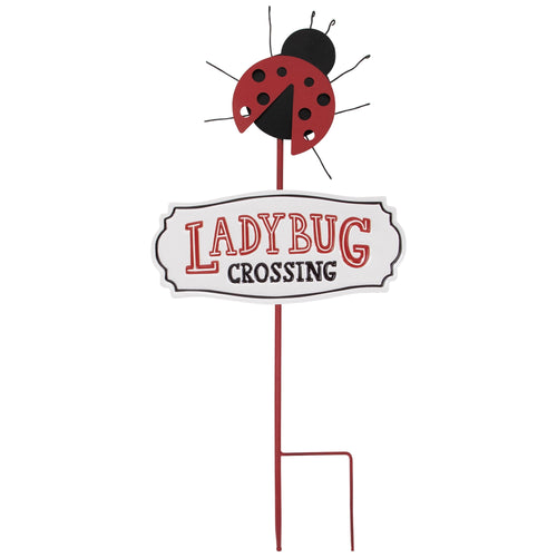 Metal garden stake with a red ladybug figure above a white 'Ladybug Crossing' sign on a plain background
