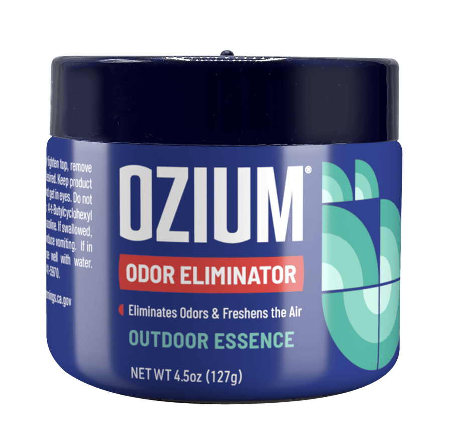 Close-up of a blue Ozium odor eliminator gel jar labeled Outdoor Essence with geometric scent graphics