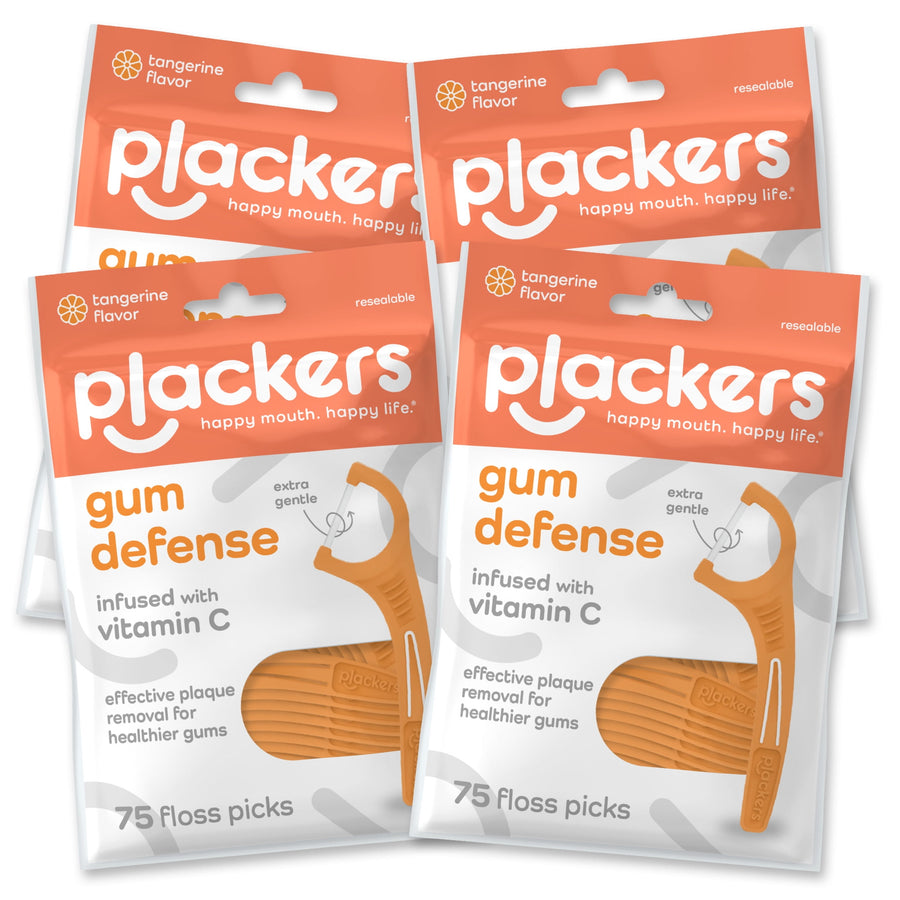 Four resealable orange-and-white Plackers Gum Defense packaging pouches shown together, front view.