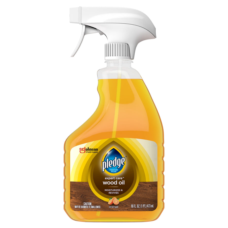 Front view of a Pledge Expert Care wood oil trigger spray bottle with orange liquid and label