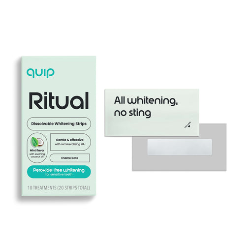 Boxed quip Ritual dissolvable whitening strips with two sample strip packets and an exposed strip on a white background