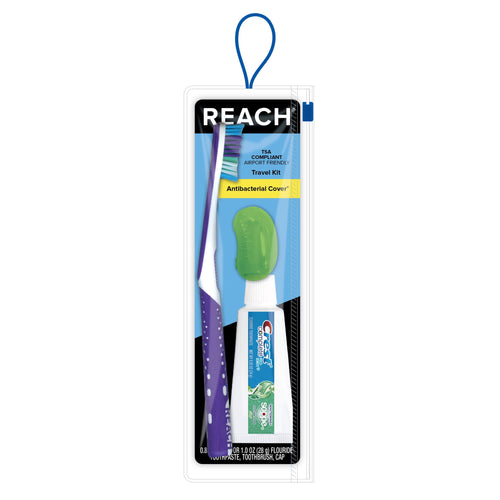 Reach travel dental kit in clear blister pack showing a purple toothbrush, small toothpaste tube and green antibacterial cover on blue backing