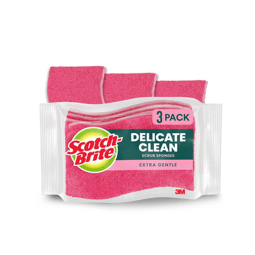 Packaged three-pack of pink Scotch-Brite Delicate Clean scrub sponges shown with one sponge partially behind the package