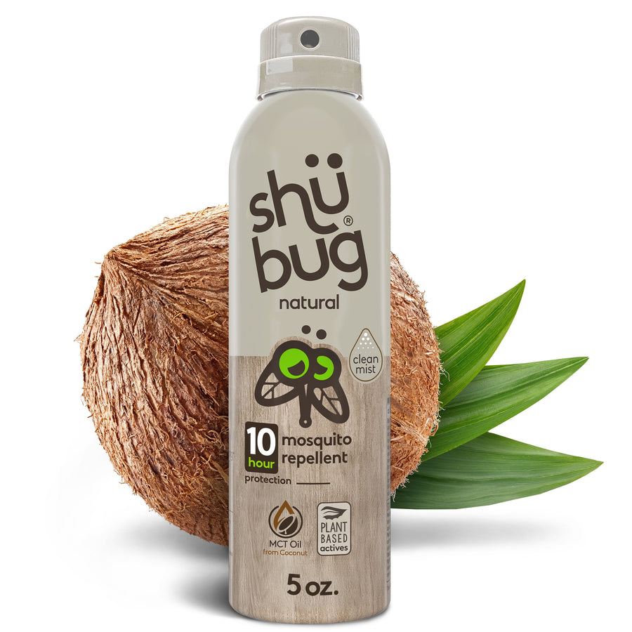 Tall aerosol can of Shūbug natural mosquito repellent standing against coconuts and green leaves.