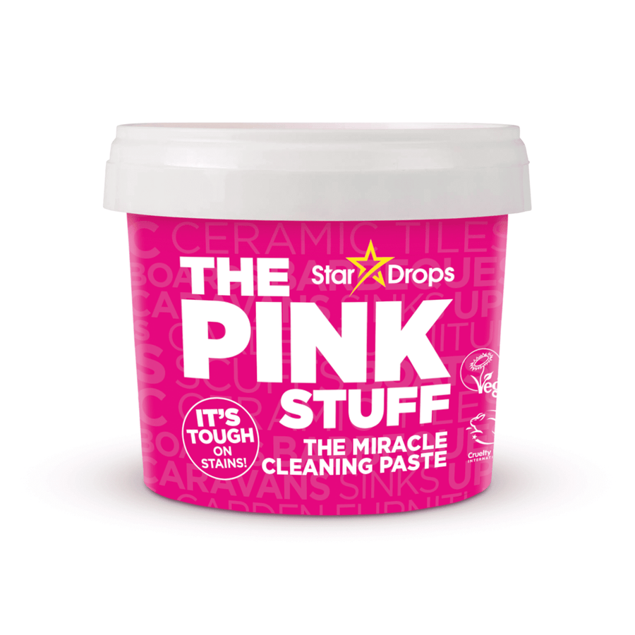 Close-up product shot of a pink and white tub labeled 'The Pink Stuff' cleaning paste with white lid.