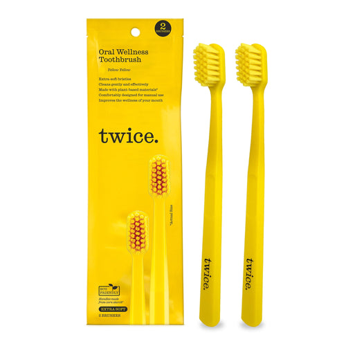 Two yellow Twice manual toothbrushes shown next to the product packaging pouch with brand name and toothbrush images.
