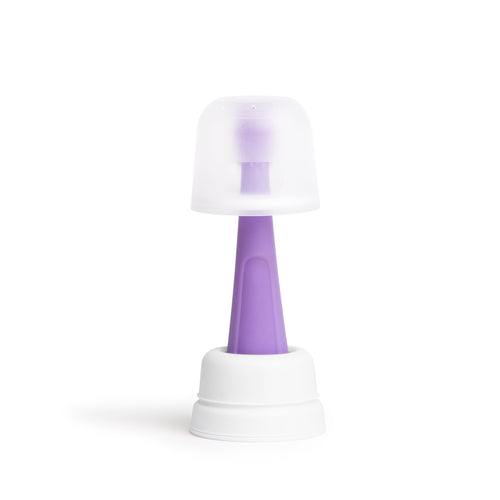Ubbi purple silicone baby training toothbrush displayed upright with a translucent protective cover on a white background.