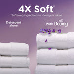 Stacked white towels and lavender sprig with text ‘4X Soft’ comparing detergent alone and with Downy