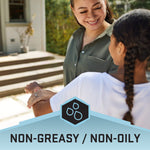 Smiling adult applying product to a child’s arm with a banner reading non-greasy / non-oily