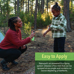 Adult spraying Natrapel Kids repellent onto a child's arm at a wooded campsite with an 'Easy to Apply' info box.