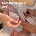 Adult hands using a sanitizing wipe on a child's hand during a picnic, with text stating safe for all family use