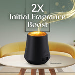 Promotional image of an Air Wick diffuser on a table with text '2X Initial Fragrance Boost' and a golden fragrance stream.