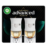 Two white Air Wick advanced plug-in warmers shown inserted in outlets with golden scented oil reservoirs on dark decorative background.
